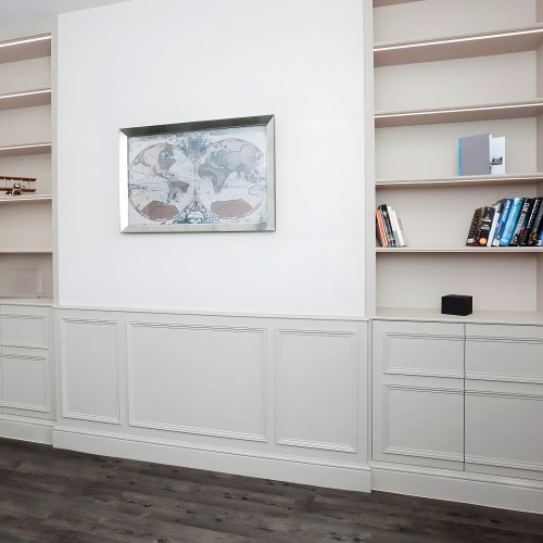 Grey alcove bookshelves with cupboards below and panelling between them
