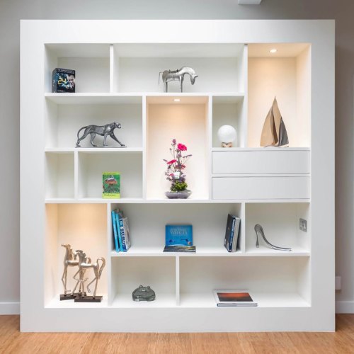 White display shelving with lit open compartments, set between two doorways